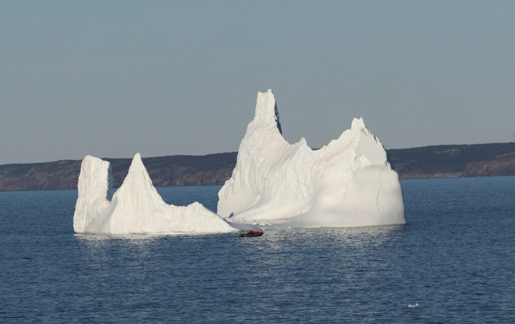 Huge iceberg on the Bonavista peninsula of Newfoundland with Sea of Whales boat in front of it